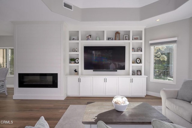 living room with dark hardwood / wood-style floors and a large fireplace