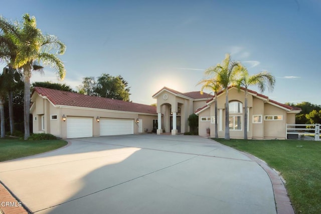 mediterranean / spanish-style house featuring a garage and a front lawn