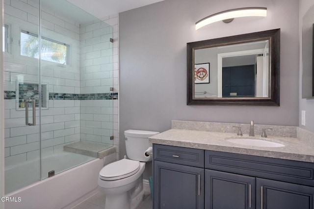 full bathroom featuring vanity, combined bath / shower with glass door, and toilet