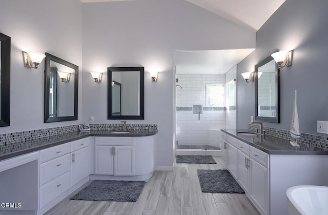 bathroom with tasteful backsplash, lofted ceiling, vanity, and an enclosed shower