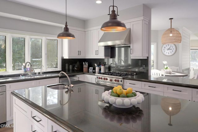 kitchen with white cabinetry, pendant lighting, and wall chimney exhaust hood