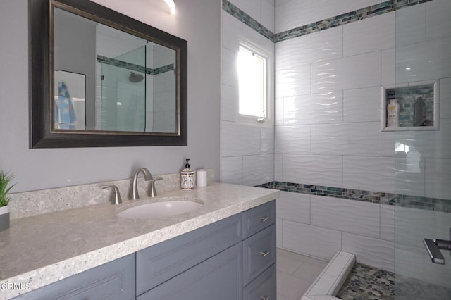 bathroom featuring vanity and tiled shower