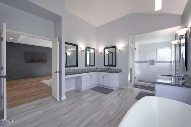 bathroom featuring vanity, lofted ceiling, wood-type flooring, and separate shower and tub