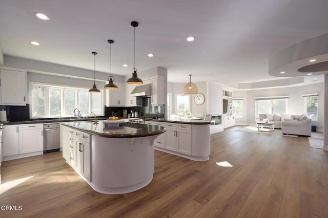 kitchen featuring pendant lighting, white cabinetry, a kitchen island, dark hardwood / wood-style flooring, and wall chimney exhaust hood