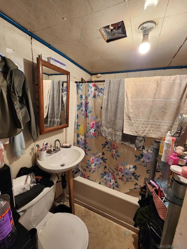 full bathroom featuring sink, toilet, and shower / bathtub combination with curtain