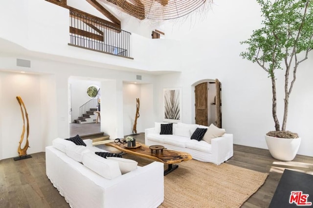 living room with a high ceiling and dark hardwood / wood-style flooring