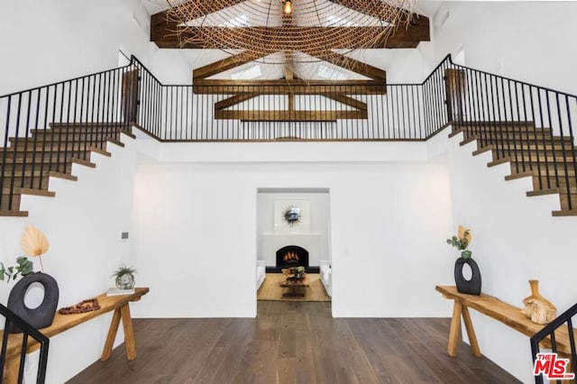 stairs with a high ceiling and wood-type flooring