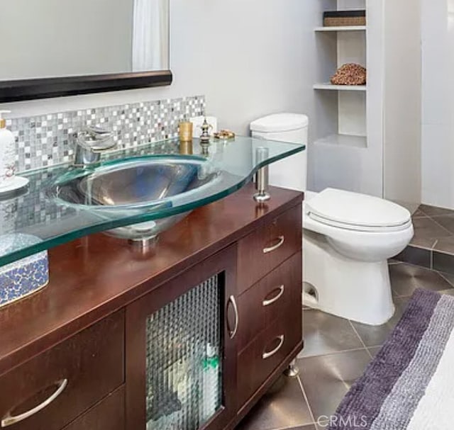 bathroom featuring toilet, vanity, tasteful backsplash, and tile patterned flooring