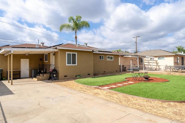 view of front of house featuring cooling unit, a front lawn, solar panels, and a patio