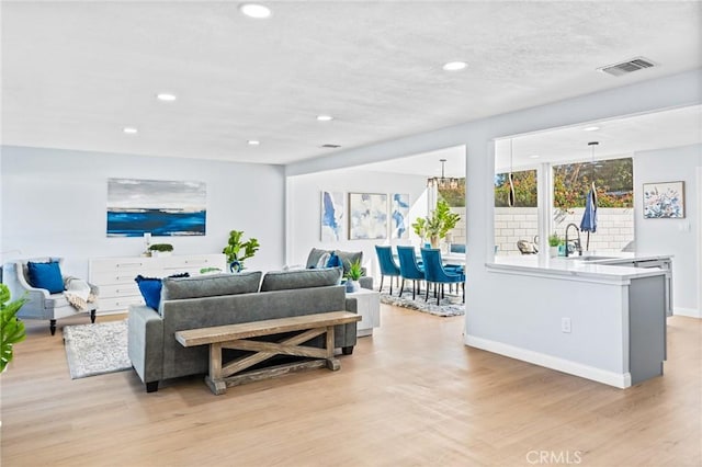 living room featuring sink and light hardwood / wood-style flooring