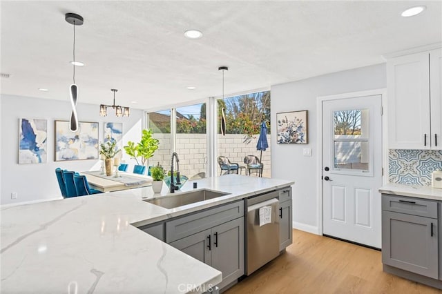 kitchen with sink, gray cabinets, pendant lighting, and dishwasher