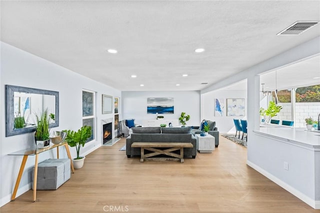 living room featuring light hardwood / wood-style floors and a high end fireplace