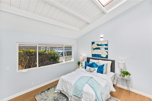 bedroom featuring wood-type flooring and vaulted ceiling with skylight