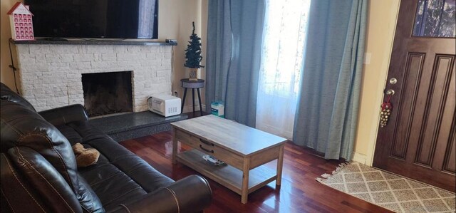 living room with dark hardwood / wood-style floors and a fireplace