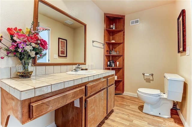 bathroom featuring wood-type flooring, toilet, and vanity