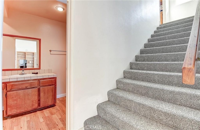 stairs with sink and hardwood / wood-style floors