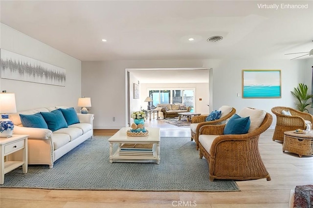 living room featuring ceiling fan and light hardwood / wood-style flooring