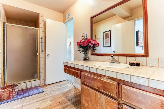 bathroom featuring vanity, an enclosed shower, and hardwood / wood-style floors