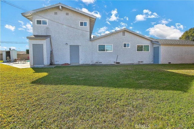 rear view of property featuring a yard and a patio area