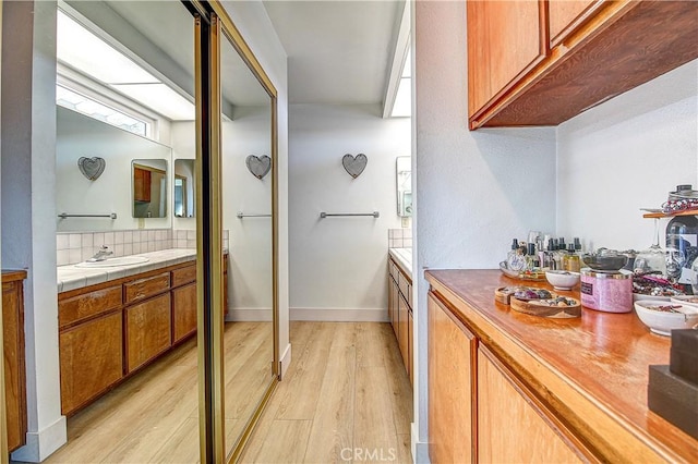 interior space featuring vanity, hardwood / wood-style floors, and decorative backsplash