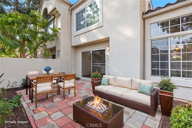 view of patio featuring an outdoor living space with a fire pit, outdoor dining area, and fence