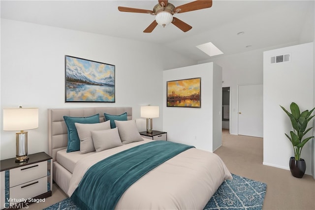 bedroom with visible vents, lofted ceiling with skylight, carpet, and a ceiling fan