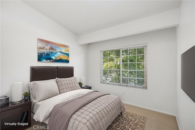 carpeted bedroom with vaulted ceiling and baseboards