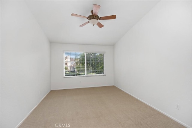 empty room featuring baseboards, light carpet, lofted ceiling, and a ceiling fan