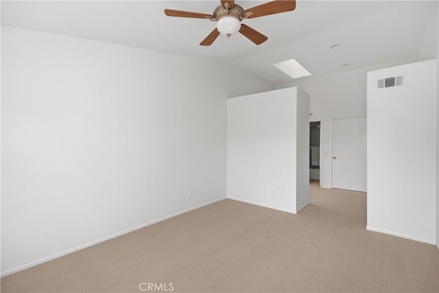 unfurnished room with baseboards, visible vents, ceiling fan, light carpet, and lofted ceiling with skylight