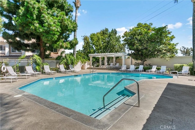 pool with a patio area, a pergola, and fence