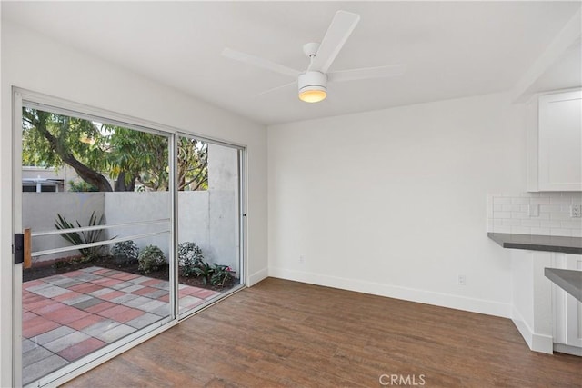 unfurnished dining area featuring a ceiling fan, wood finished floors, and baseboards