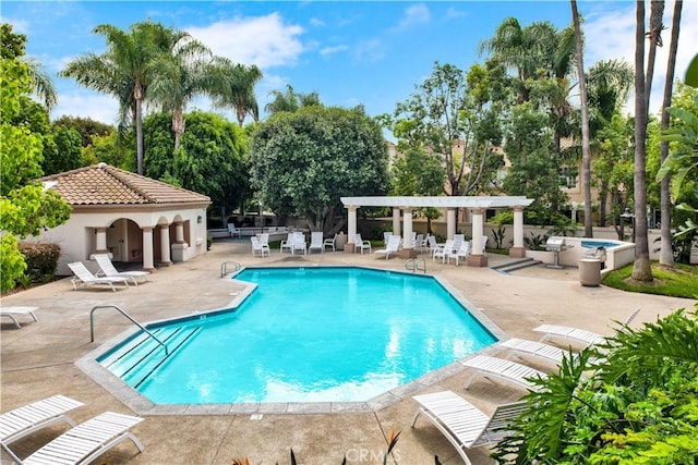 community pool with a patio, fence, and a pergola