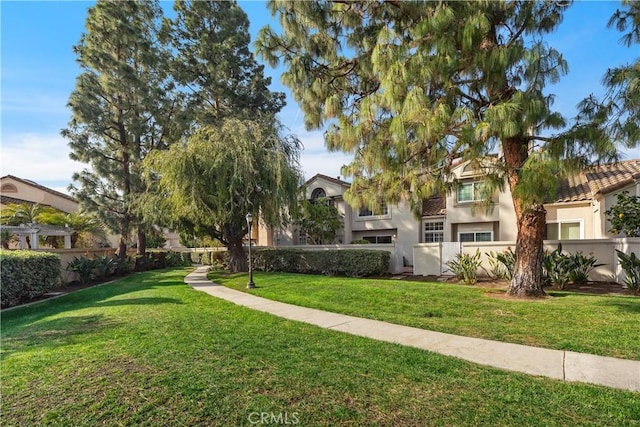 view of community with a yard and fence