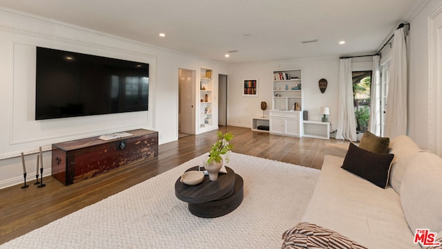 living room with dark wood-type flooring, built in features, and crown molding