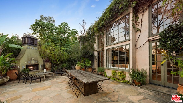 view of patio / terrace featuring an outdoor fireplace and french doors