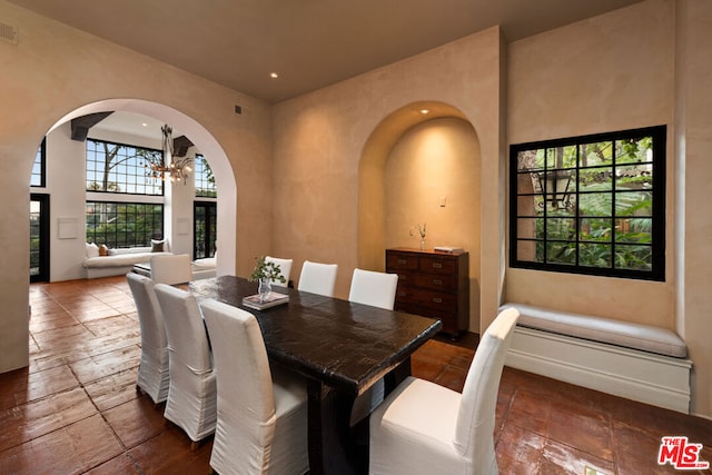 dining space featuring a high ceiling and a notable chandelier