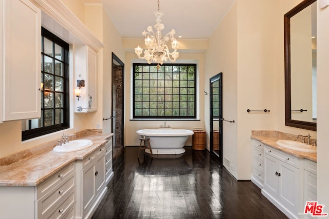 bathroom with a tub, wood-type flooring, vanity, and a notable chandelier