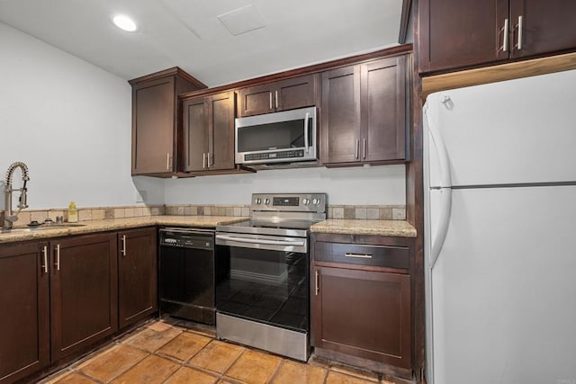 kitchen featuring sink, dark brown cabinets, light stone counters, and stainless steel appliances