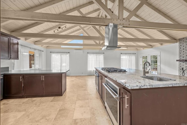 kitchen featuring island range hood, vaulted ceiling with beams, a large island, and stainless steel appliances