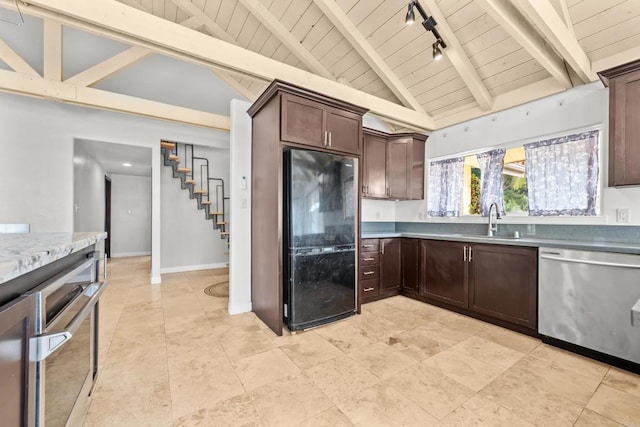 kitchen featuring dark brown cabinetry, dishwasher, black refrigerator, beamed ceiling, and sink