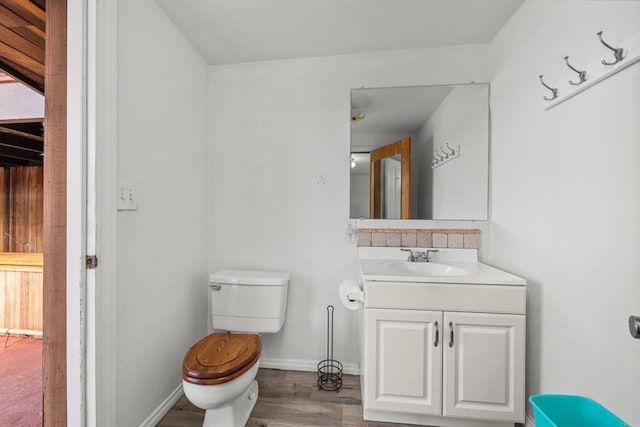 bathroom with wood-type flooring, toilet, and vanity