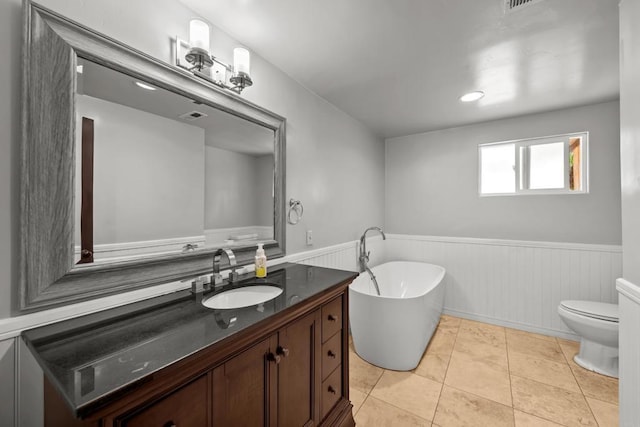 bathroom featuring vanity, toilet, tile patterned flooring, and a bathing tub