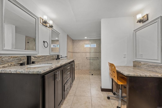 bathroom featuring tiled shower, vanity, and tile patterned flooring