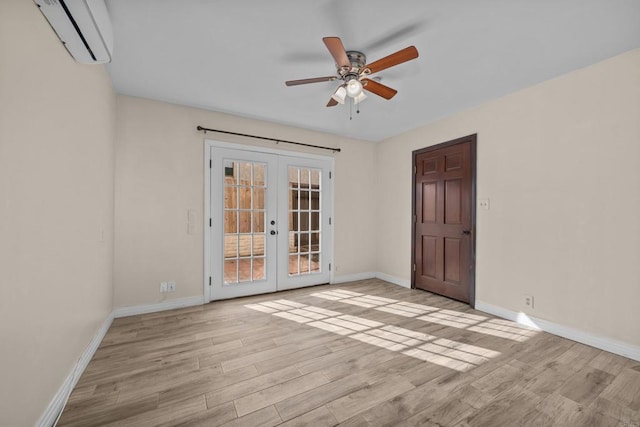 unfurnished room featuring ceiling fan, a wall mounted AC, light hardwood / wood-style flooring, and french doors