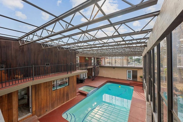 view of pool featuring an in ground hot tub and glass enclosure