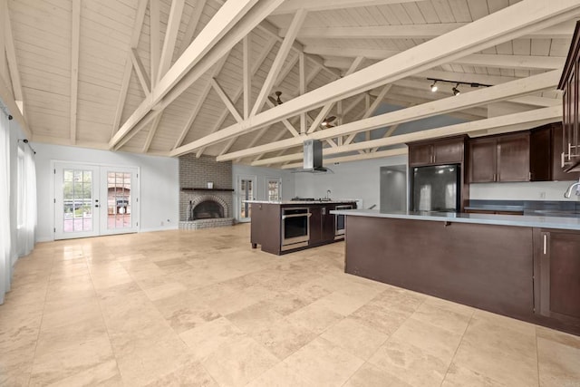 kitchen with oven, island range hood, dark brown cabinets, vaulted ceiling with beams, and black fridge