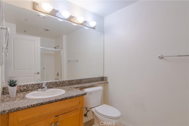 bathroom with an enclosed shower, vanity, and toilet