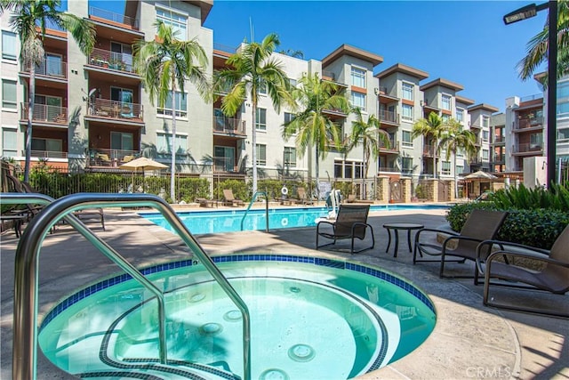 view of swimming pool with a hot tub