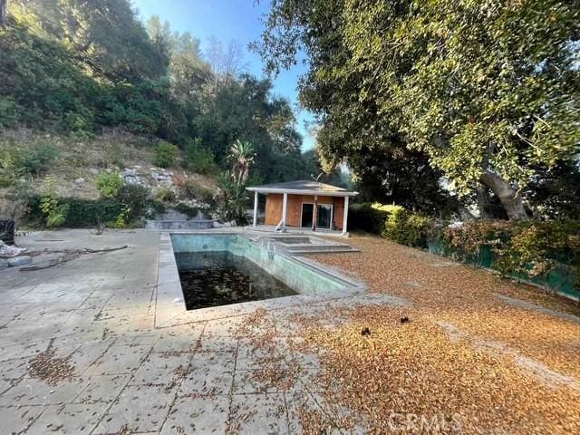 view of swimming pool featuring a patio and an outdoor structure