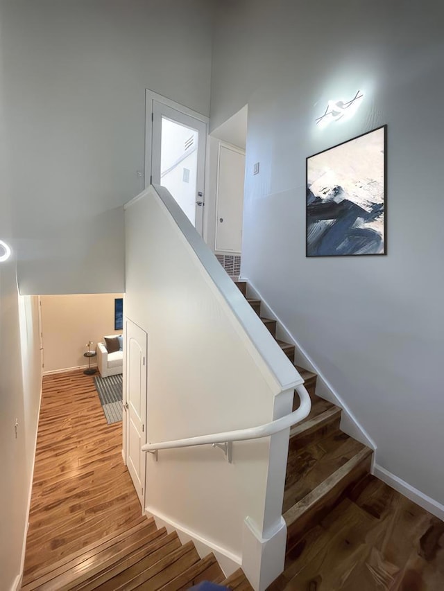 stairs featuring hardwood / wood-style floors